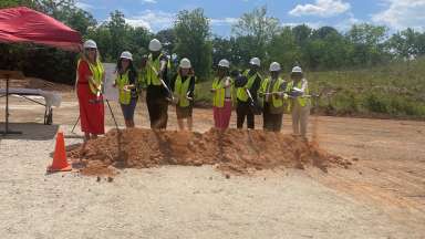 Picture of eight people shoveling dirt to signify the groundbreaking