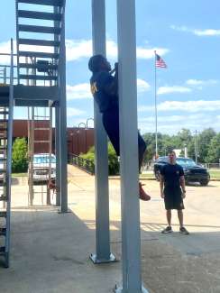 Fire recruit pulls his body up to do a pull up