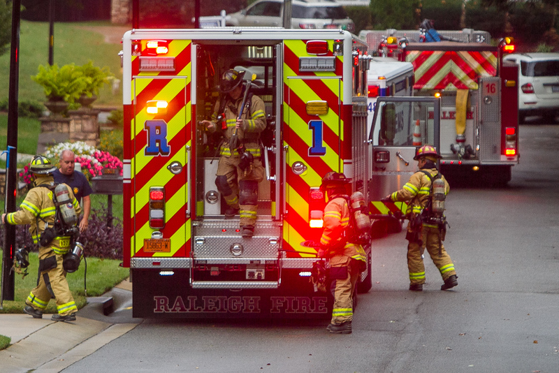 Firefighters disembarking from back of fire engine