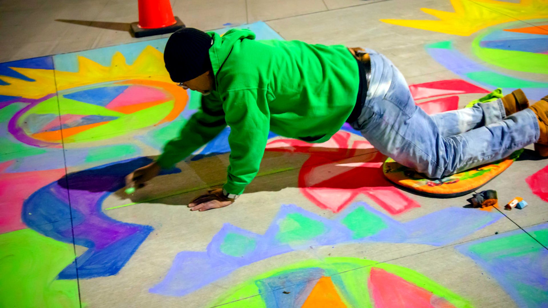 Man drawing chalk art on the sidewalk