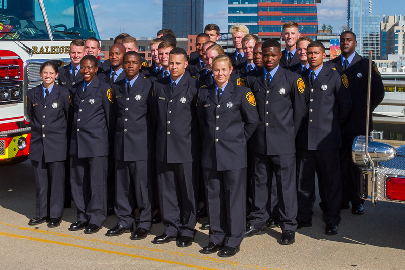 Firefighters wearing dress uniform standing in rows