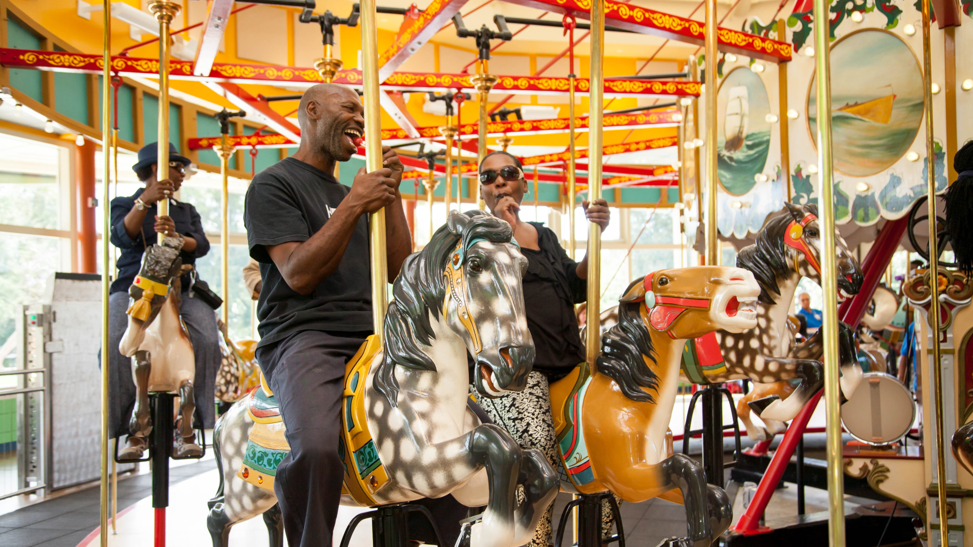 View of people riding the John Chavis Memorial Park historic carousel