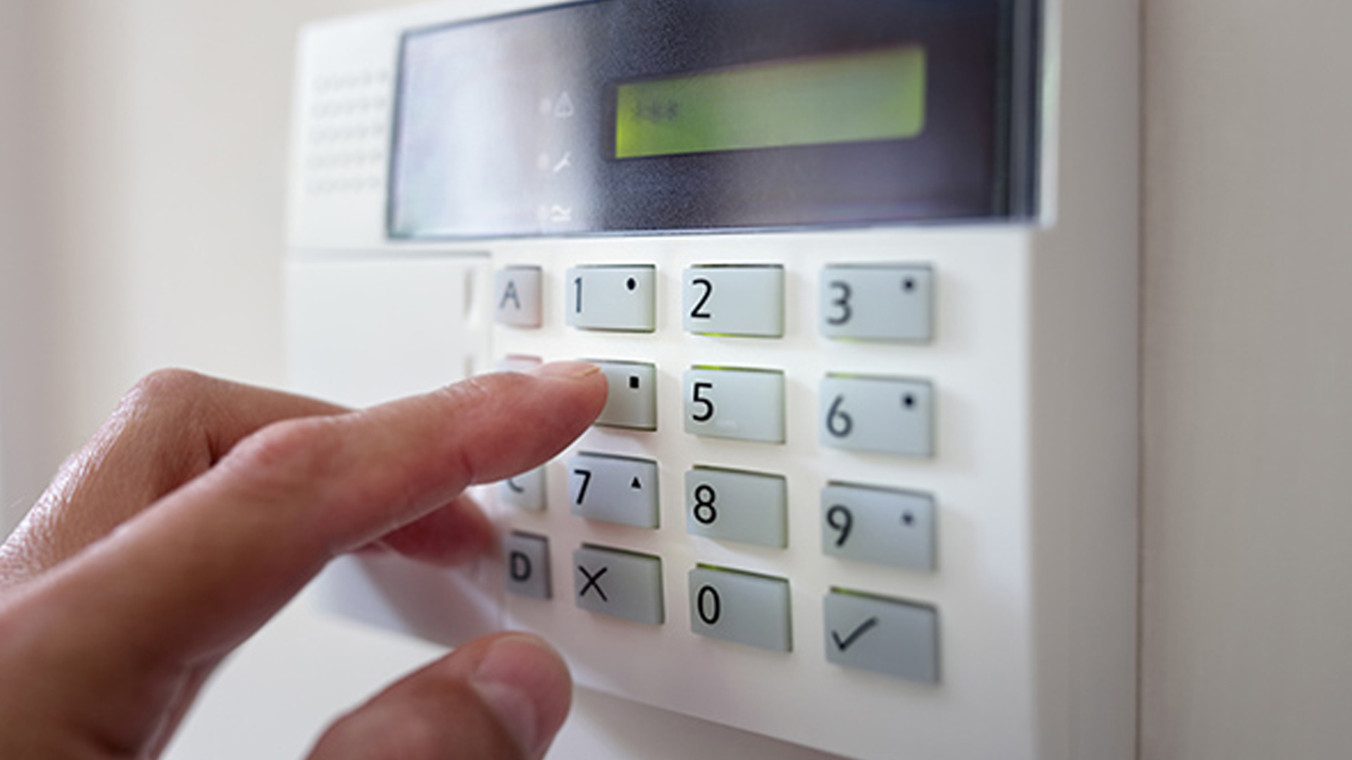 Male hand pressing the code on a house alarm