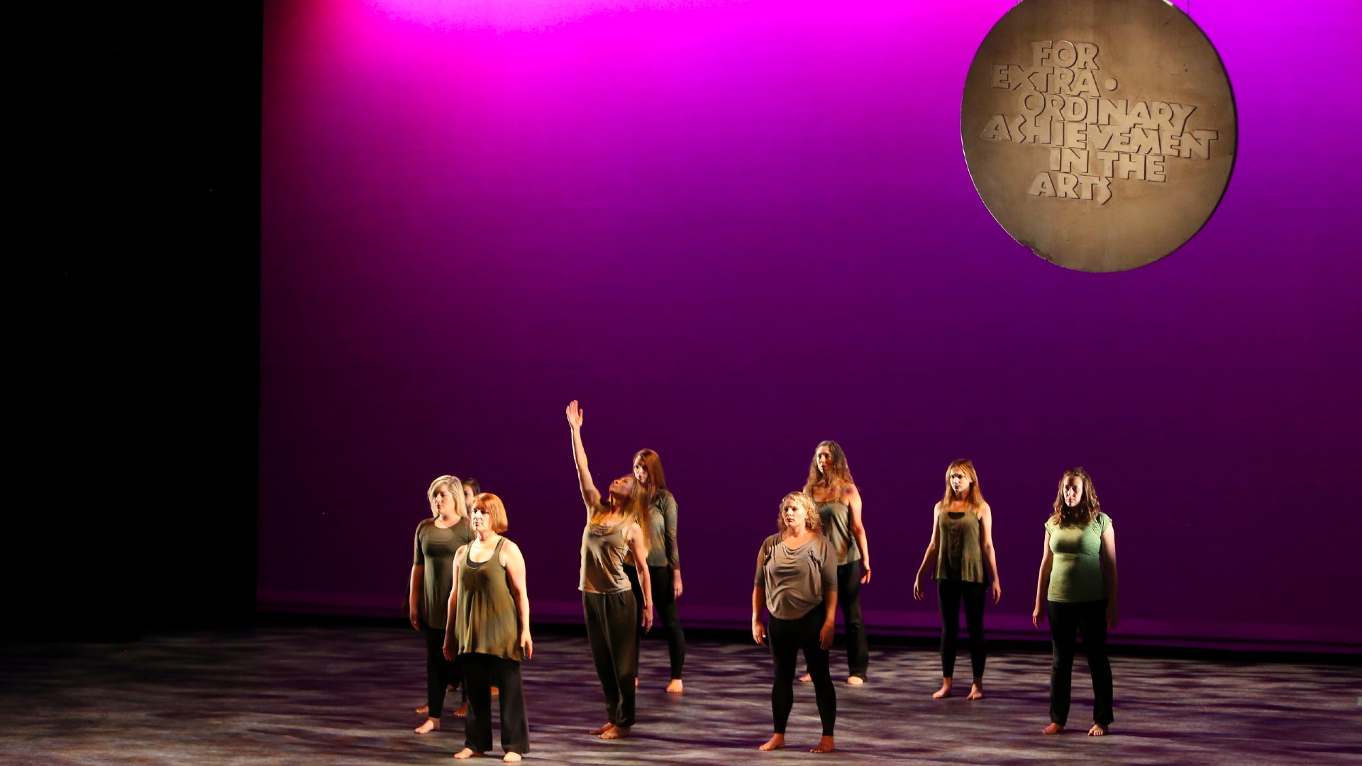 Group of people performing dance on stage for Medal of Arts program
