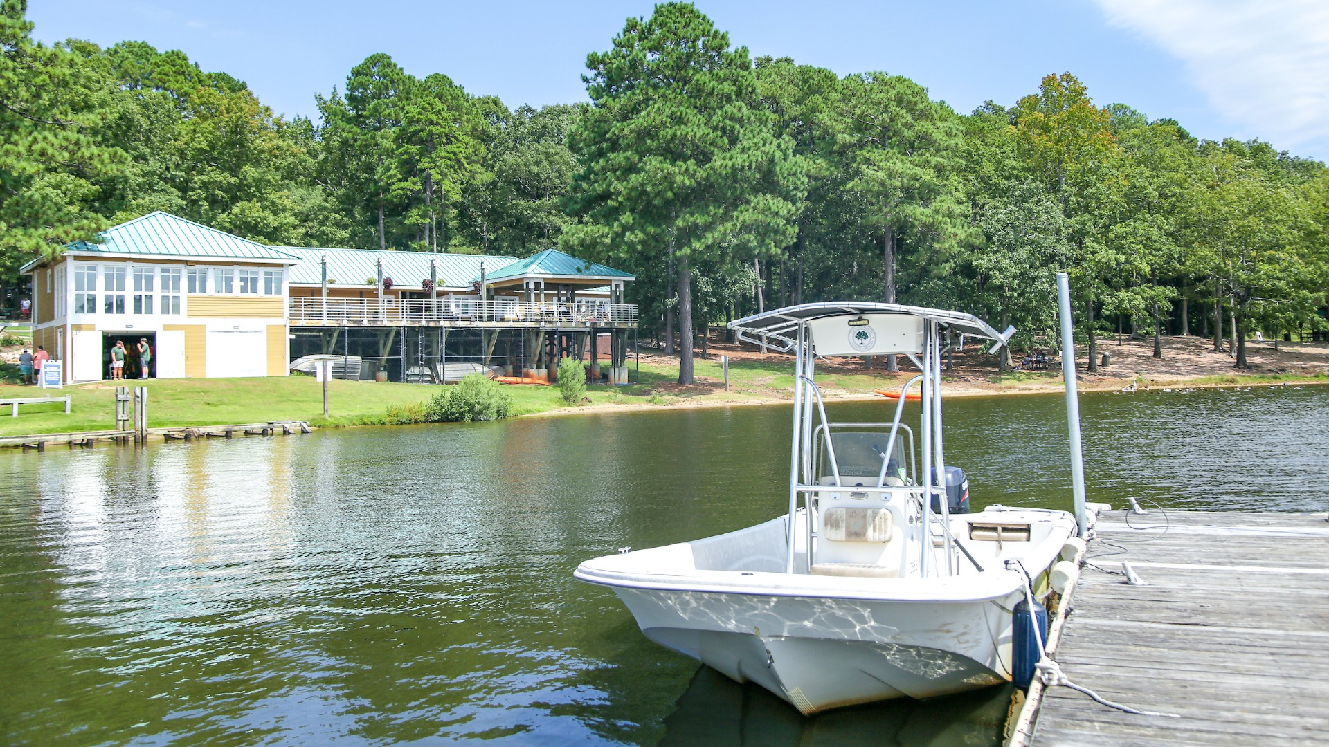 Boat at dock near pier in front of the waterfront center at Lake Wheeler
