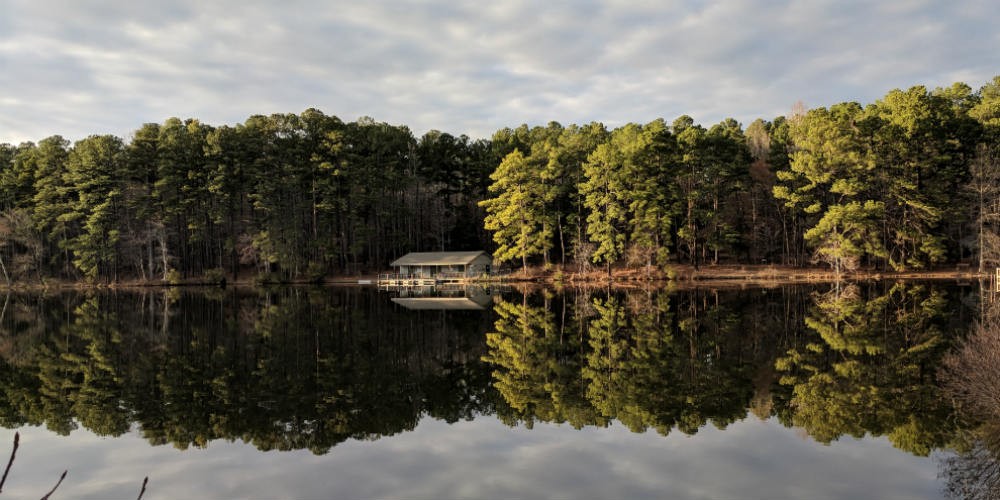 Lake view at Durant Nature Preserve with trees and cabin