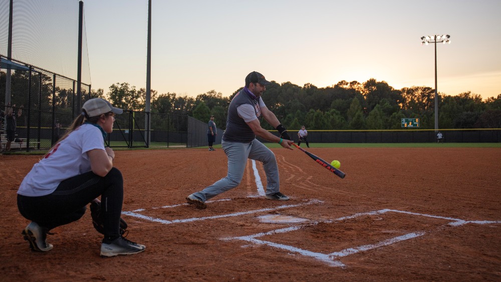 Batter hitting ball on base with catcher behind