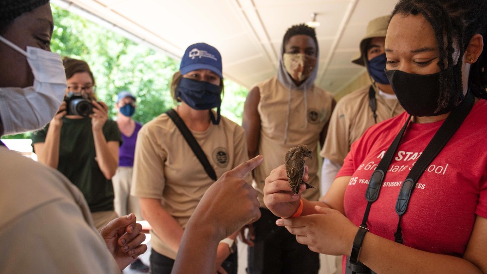 Nature instructor holding bird to show students