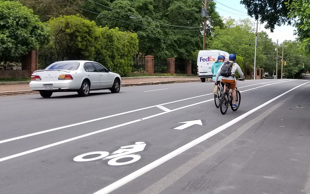 Two bikes traveling in the bike lane on Person Street near Governor's Manson, heading north 