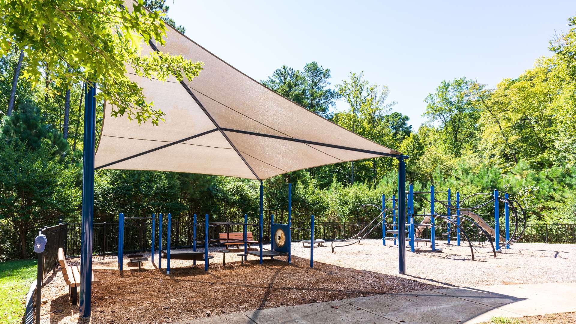 View of Leesville Park playground with bench and trees in background