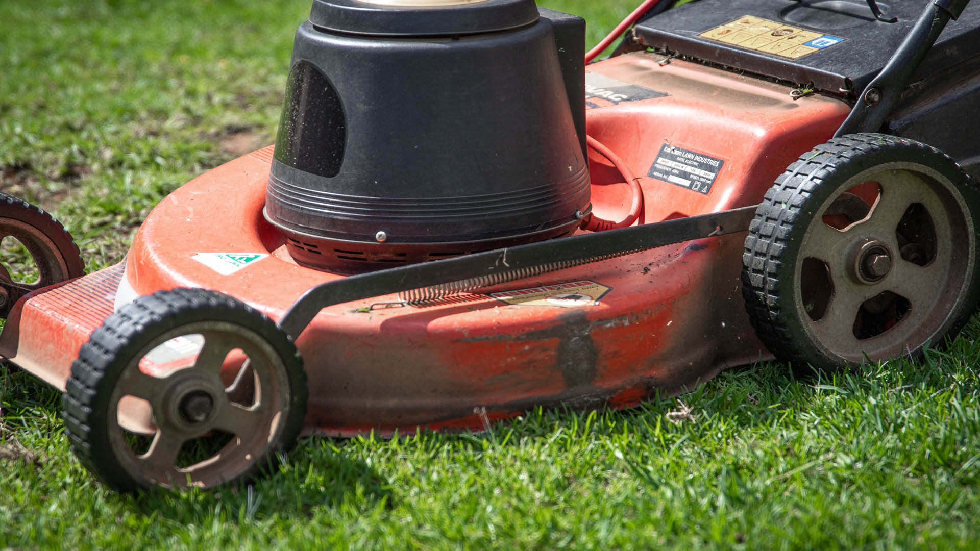 A closeup of a red lawn mower. 