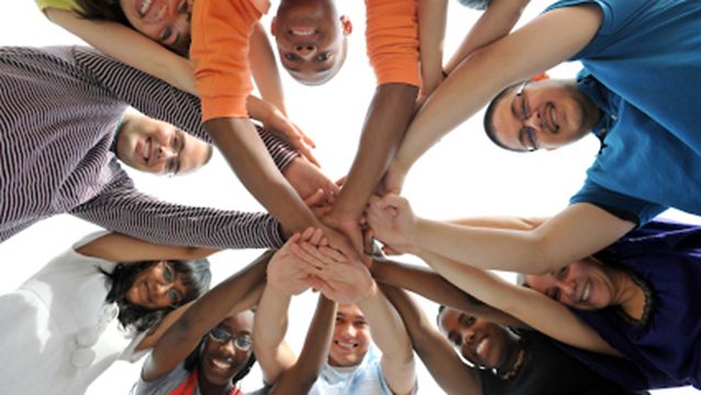 Teens in a huddle smiling