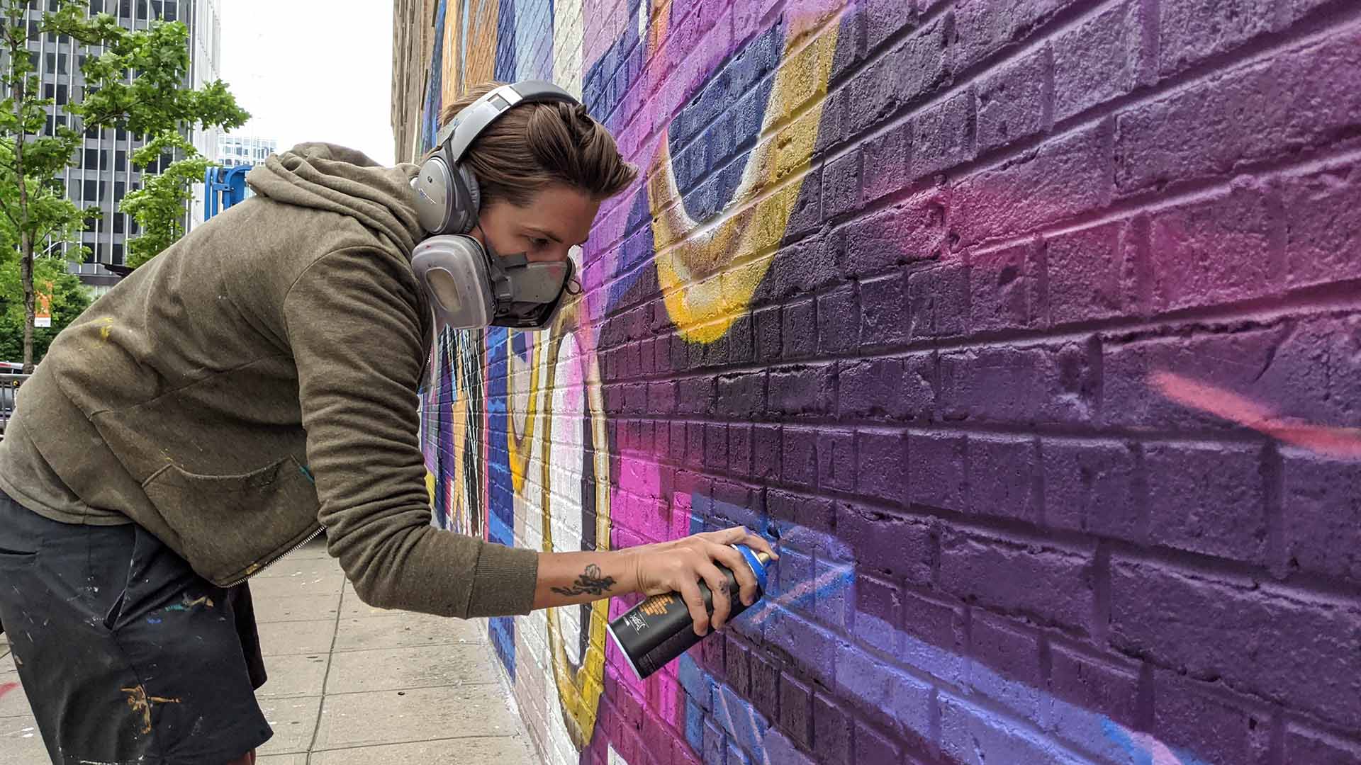 Taylor White uses spray paint to create a mural