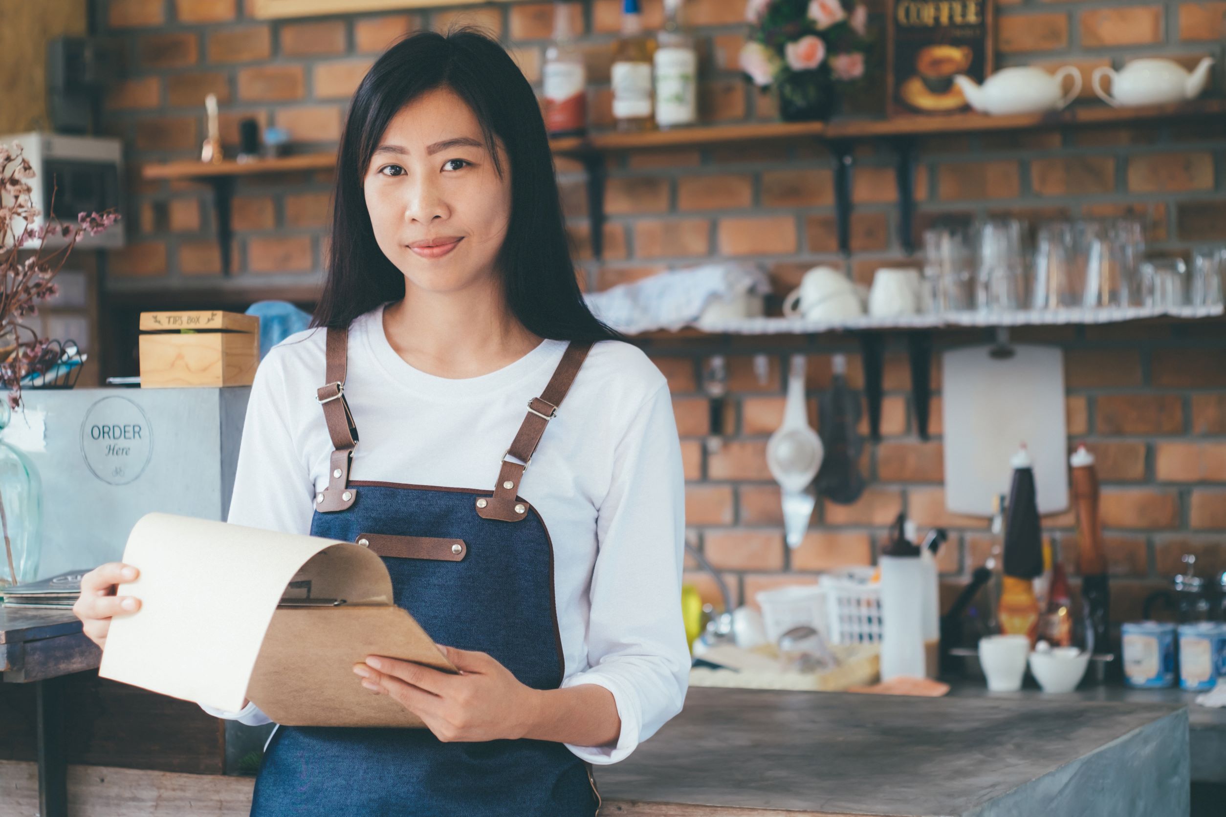 woman-wearing-apron-and-holding-clipboard