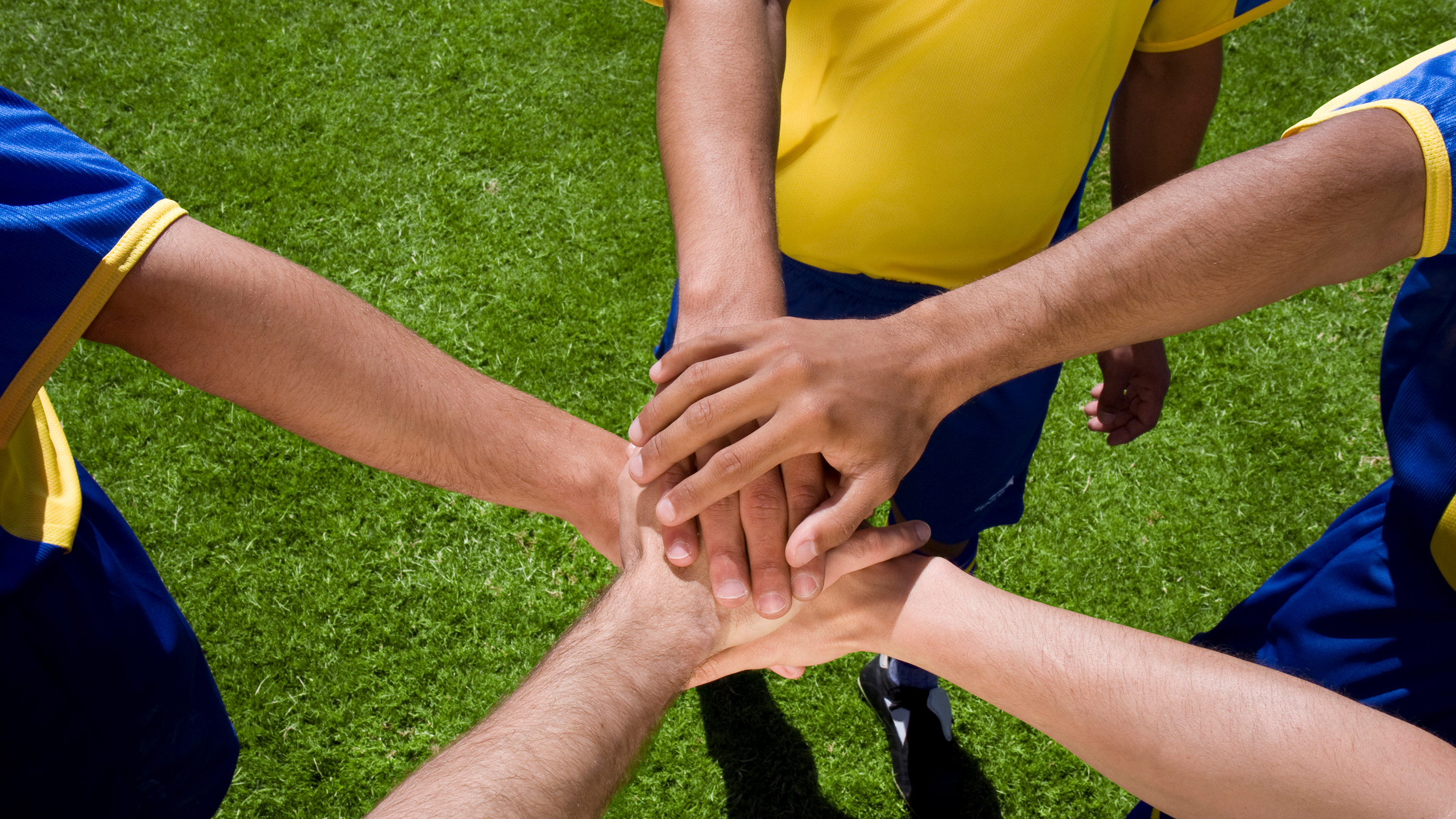 player hands stacked in a huddle