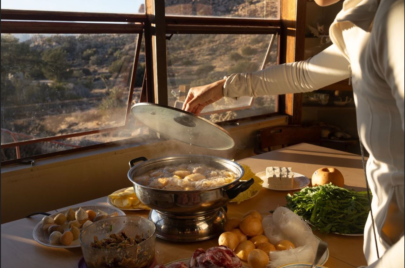 photograph of a person working with food in front of a window. 