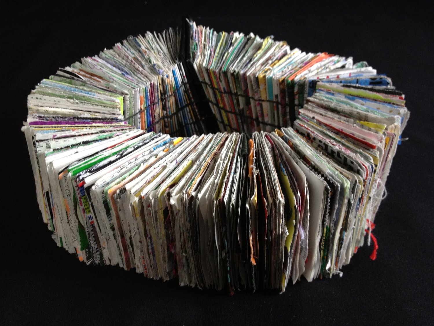 Book with handmade paper pages opening to a full circle. 