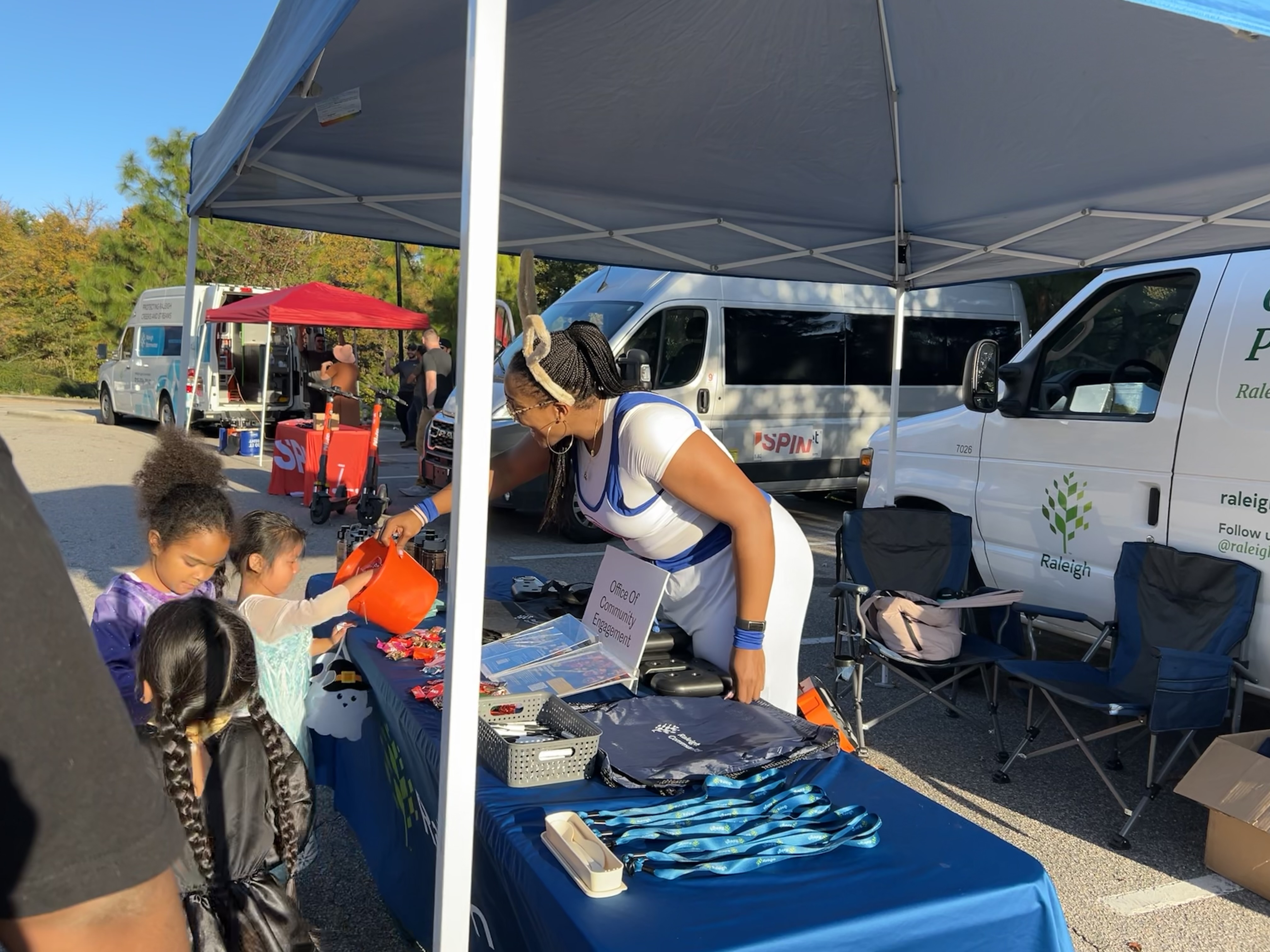 City of Raleigh staff passes out candy while standing in front of Community Engagement Van