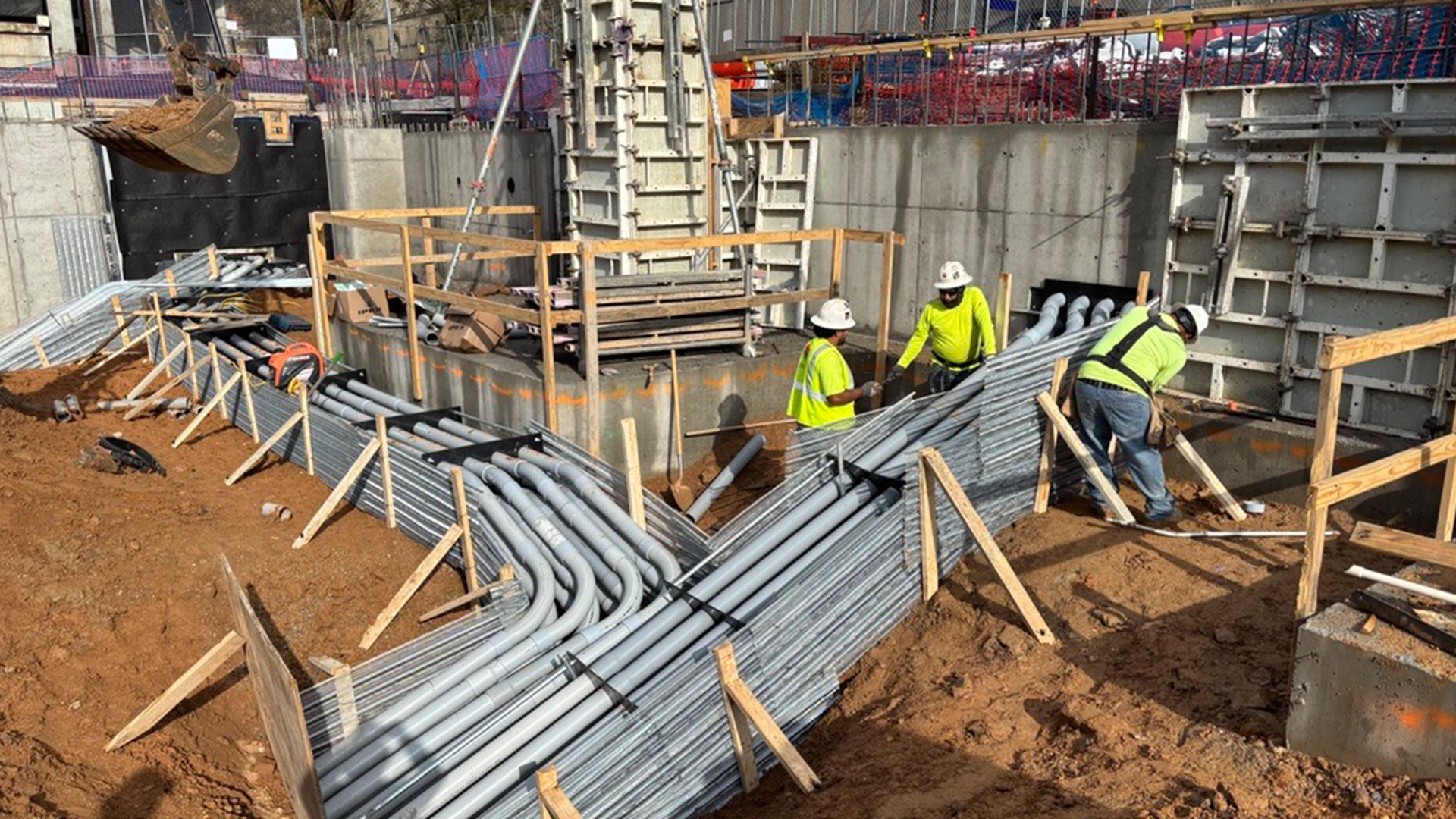 Construction works installing a huge piping system into concrete construction walls.