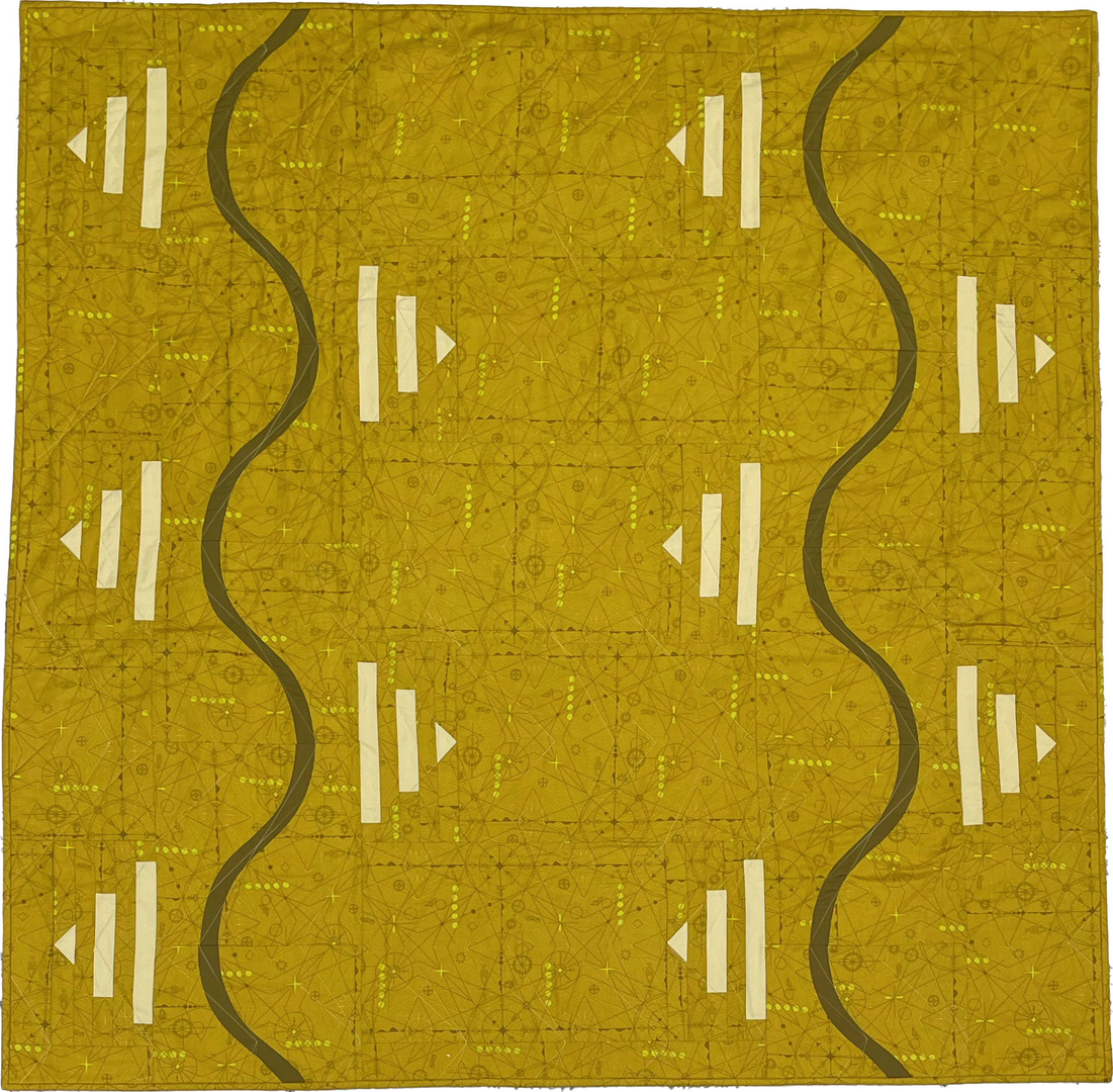 Detail of mustard colored quilt with black lines and white triangles 