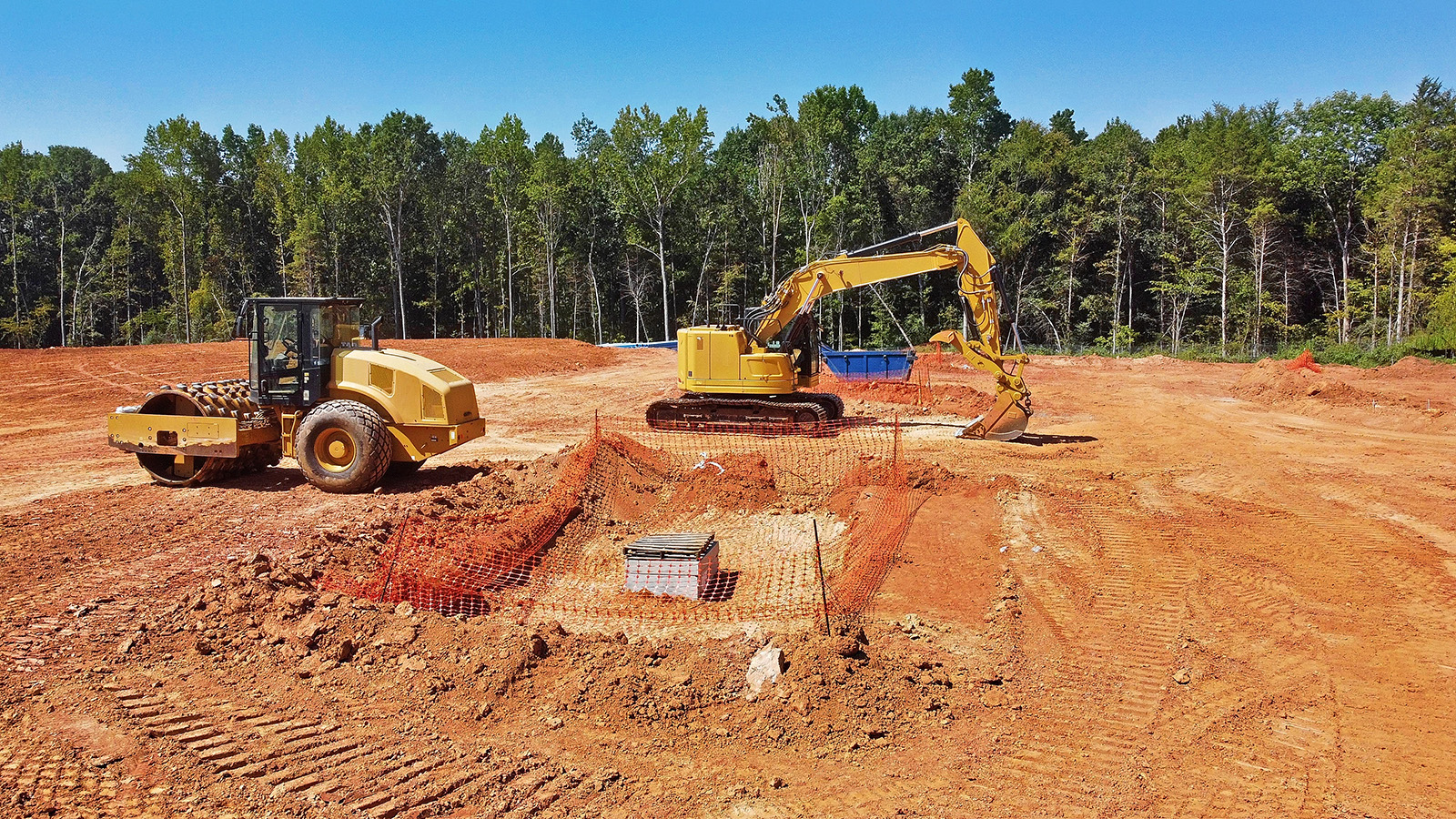 Excavator and Dump Truck Doing Land Development on Job Site