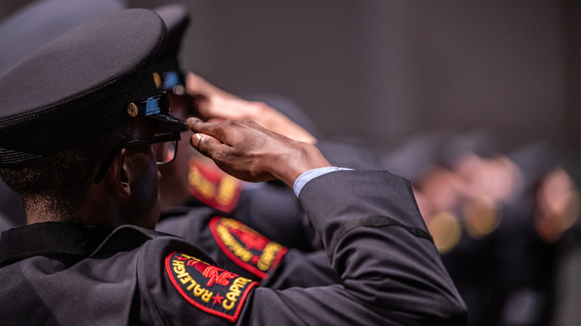 A close up shot from behind of a Raleigh Police Officer saluting