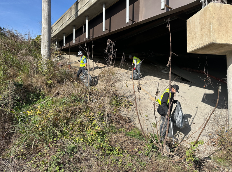 Workforce members clean trash