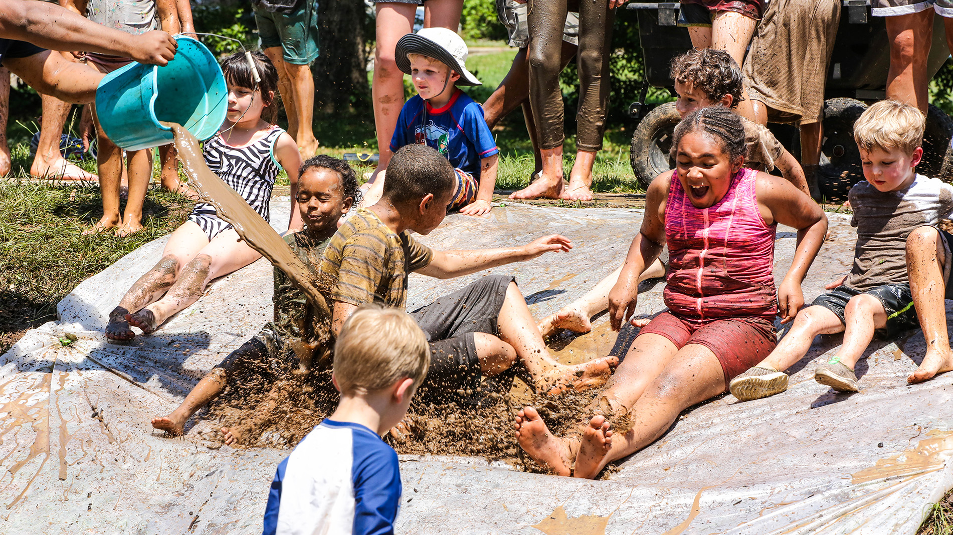 children enjoying a mud slide at Mud Day