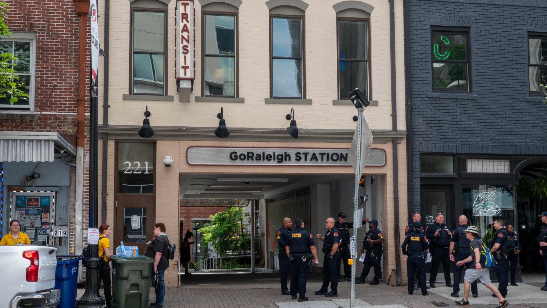 Photo of Raleigh Police officers standing on sidewalk in front of bus station