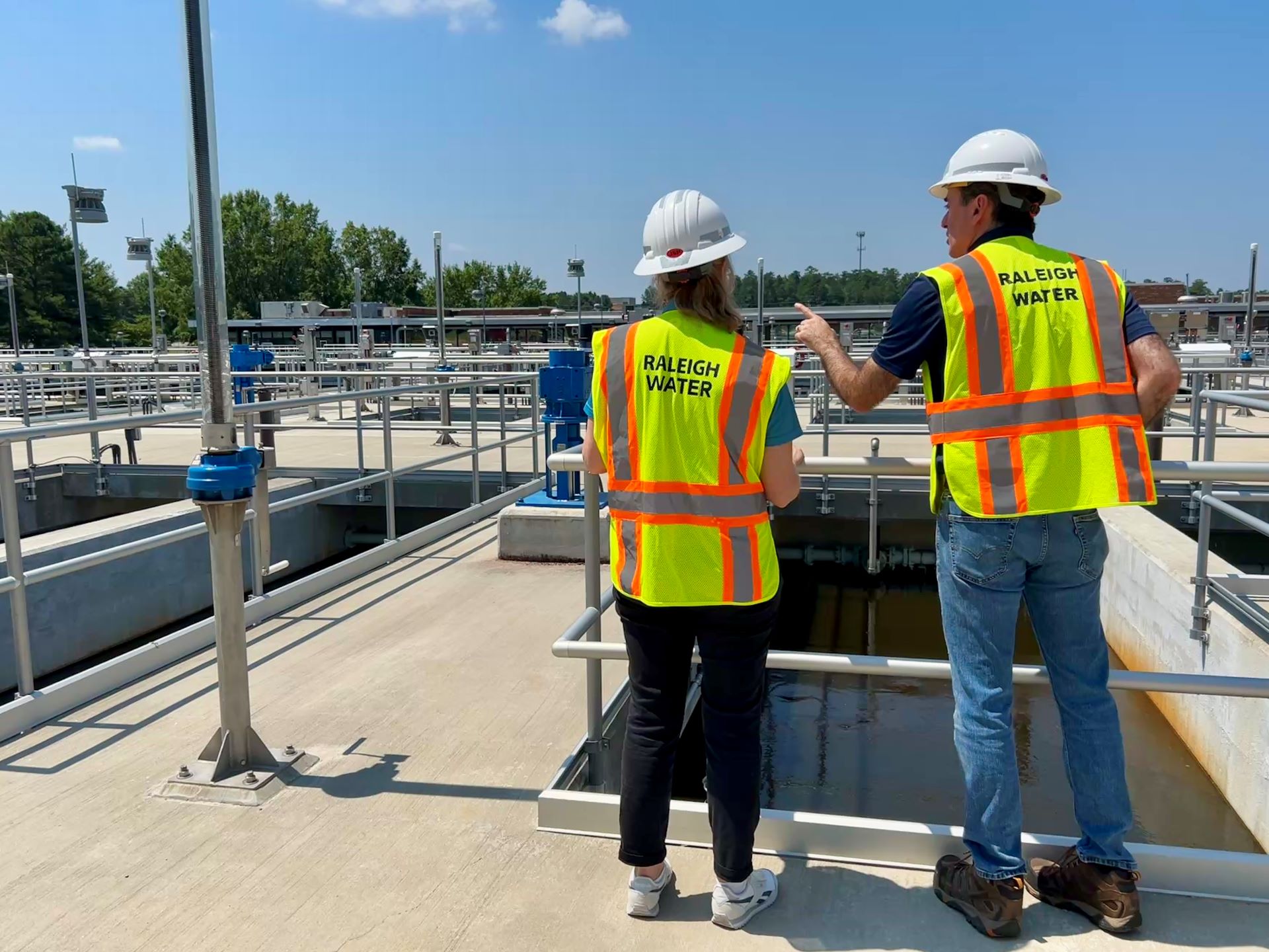 Two workers in yellow safety gear talking to eachother