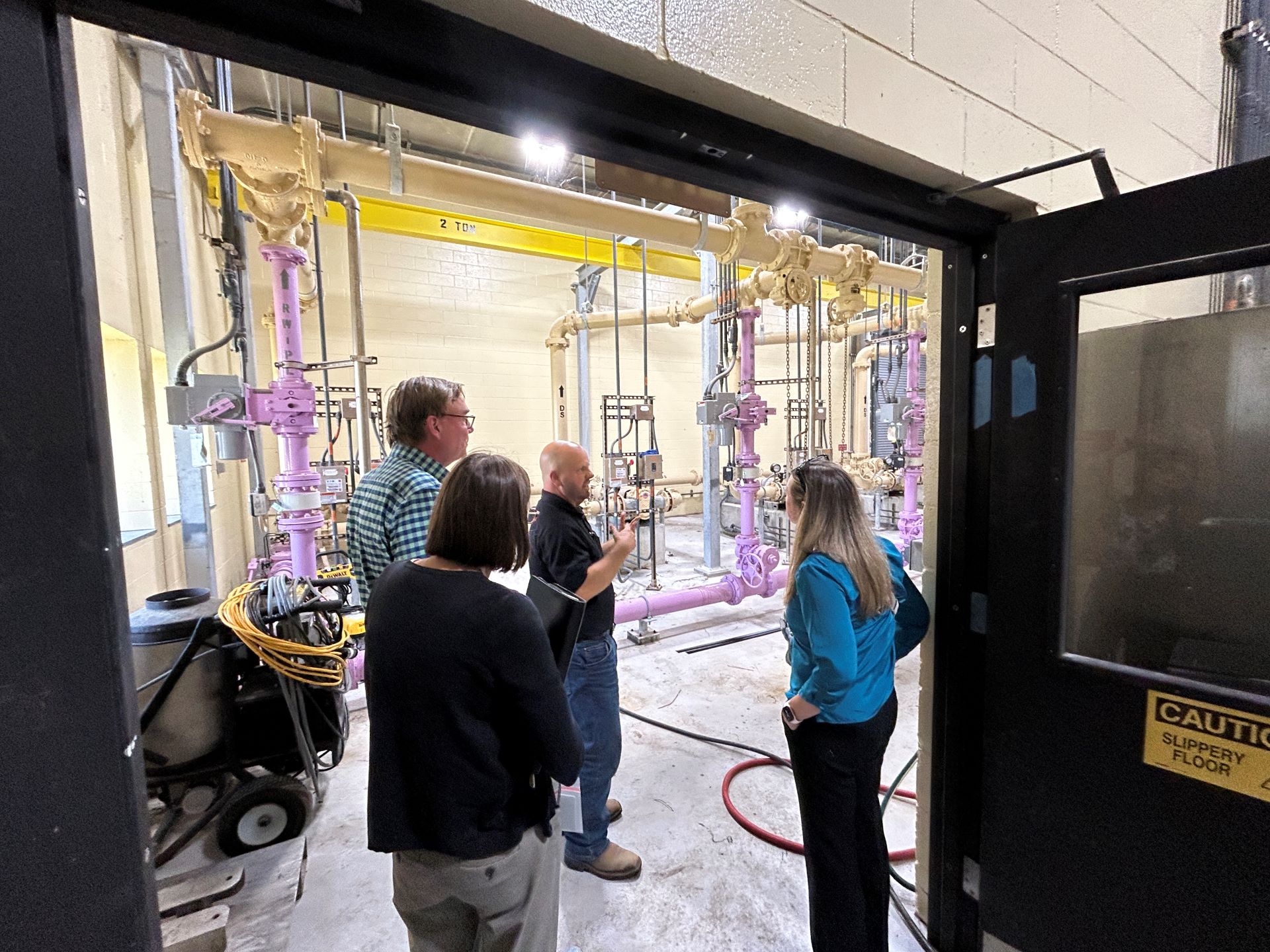 Photo of three people taking a tour of a wastewater plant
