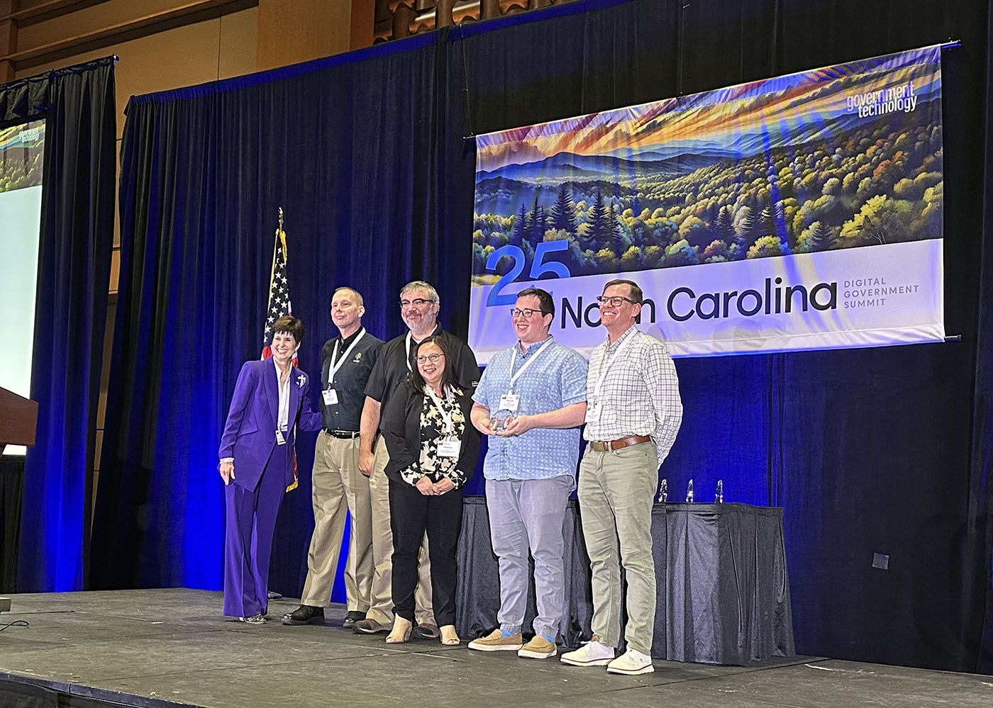 City IT employees on stage receiving an award during a conference.