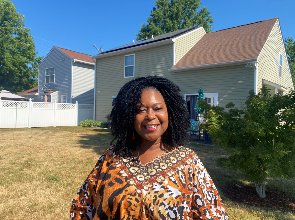 Raleigh resident stands in front of home with rooftop solar