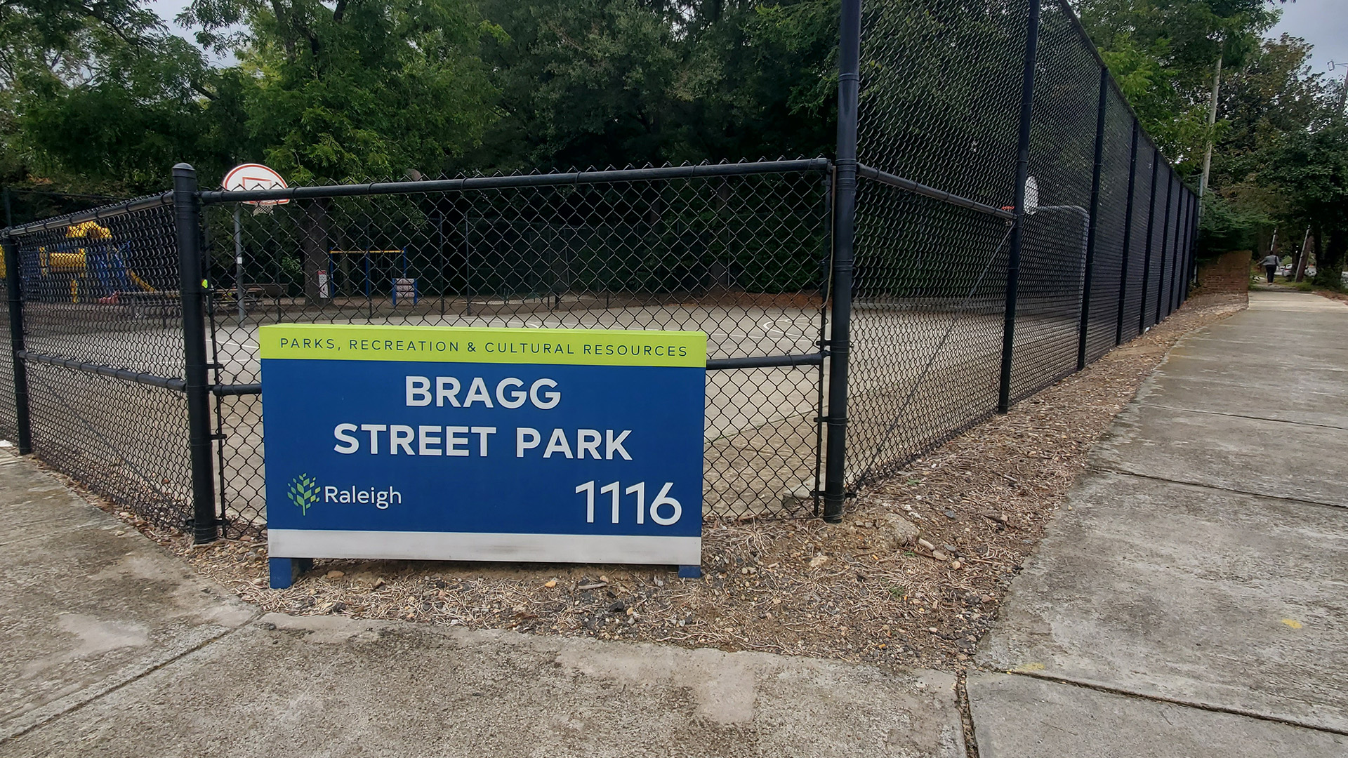 Bragg Street Park sign in front of fence where art will go