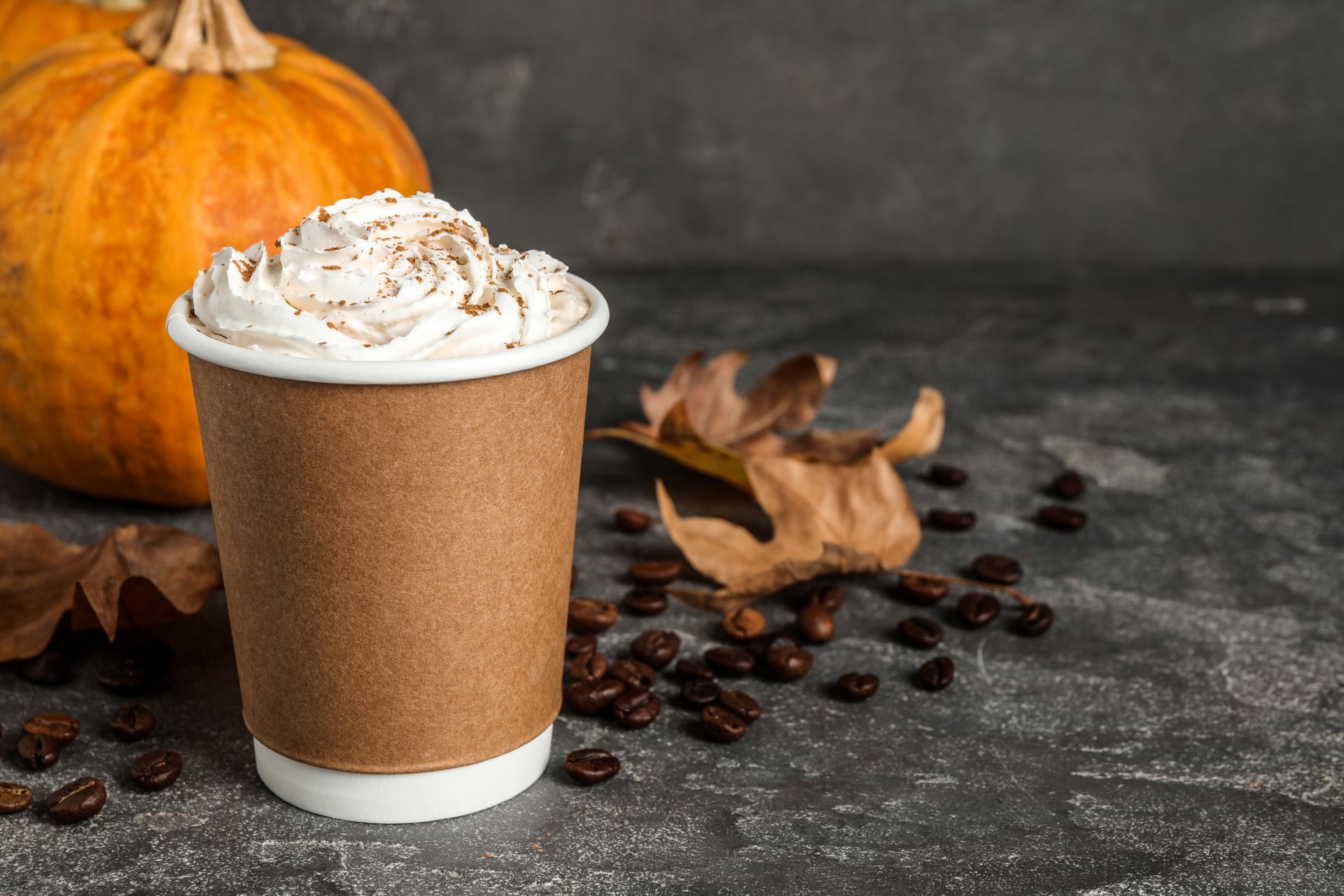 Pumpkin spice latte on table decorated with fall decorations 