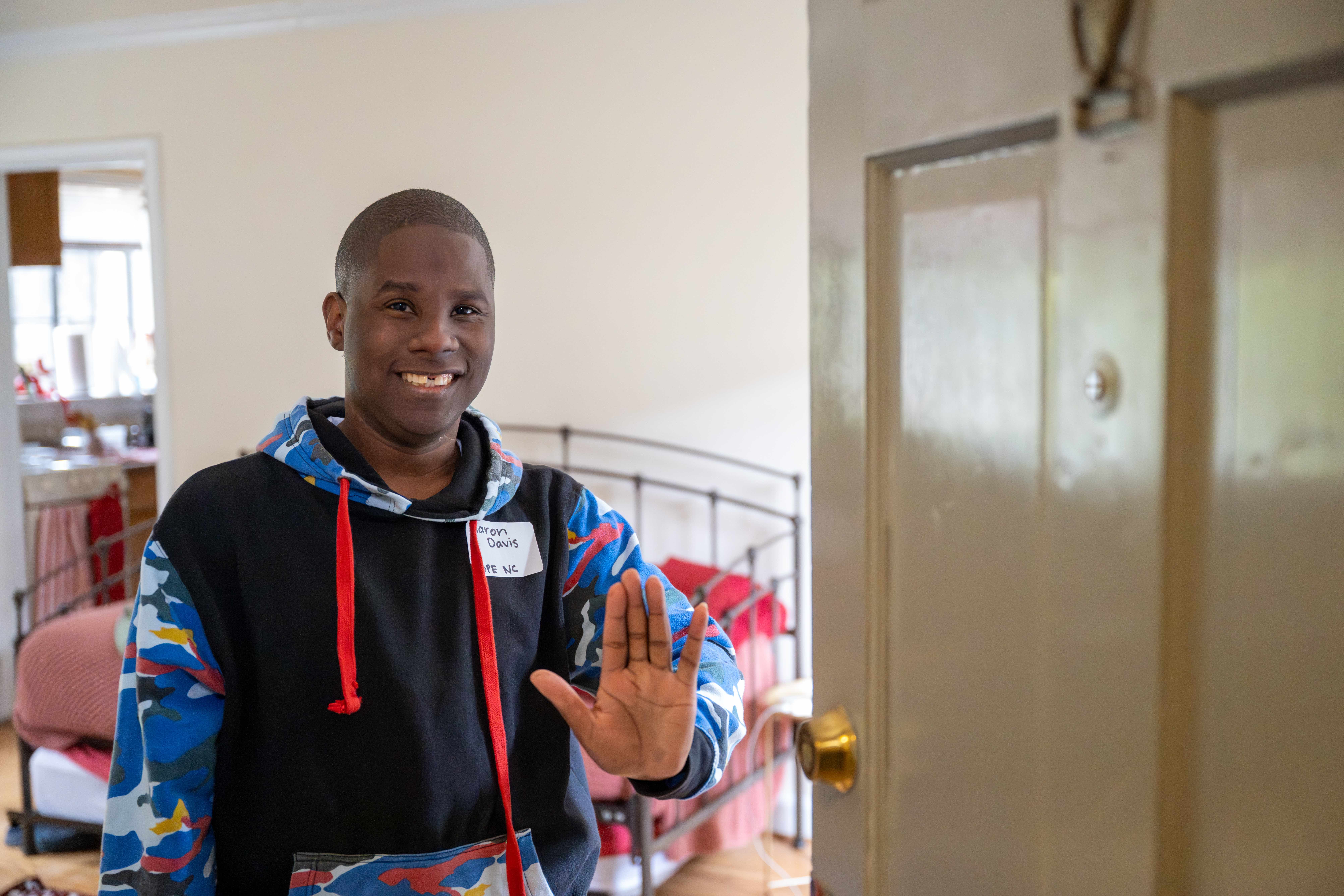 resident waving in doorway