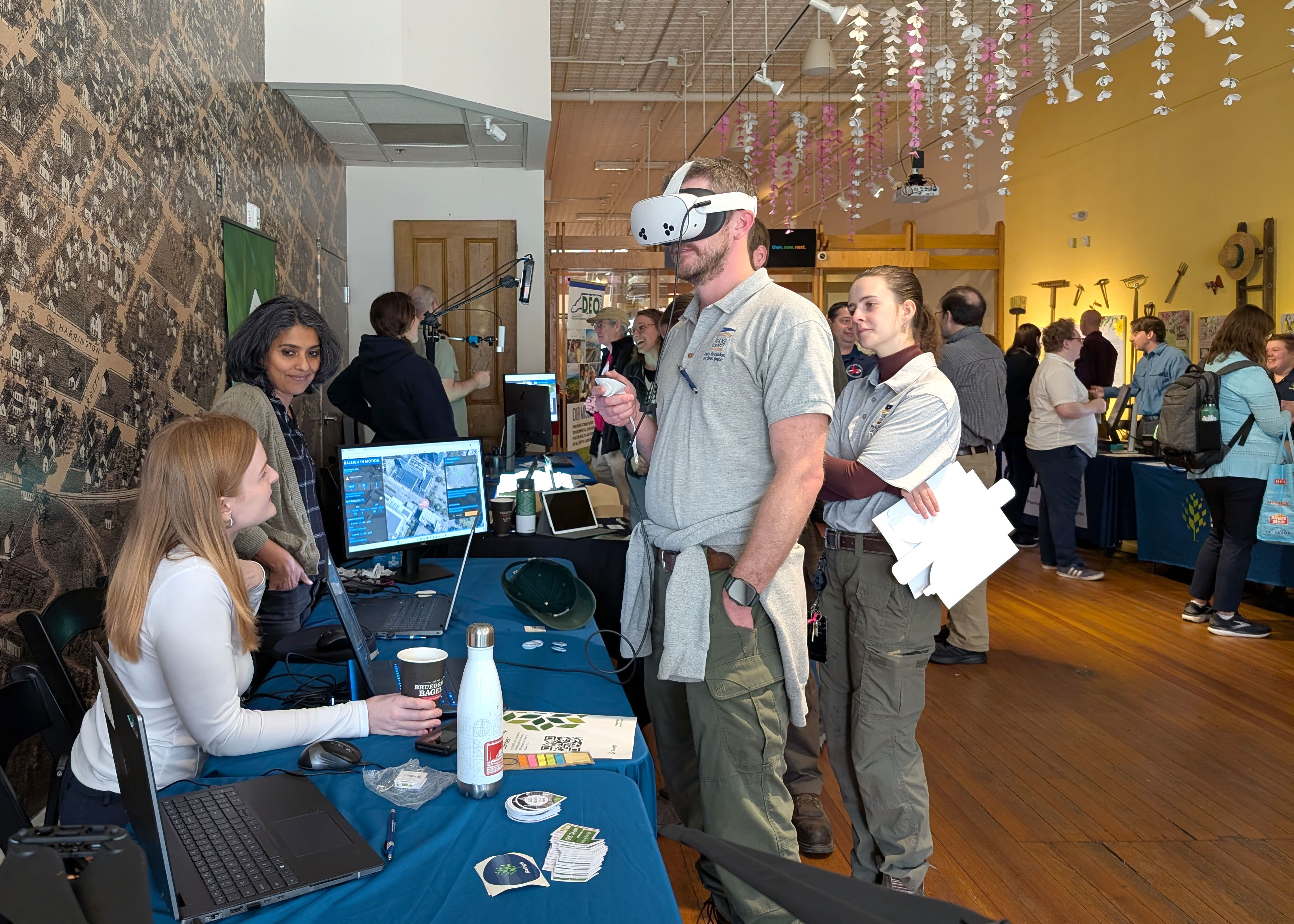GIS Day event photo from 2025. People talking at participant tables.