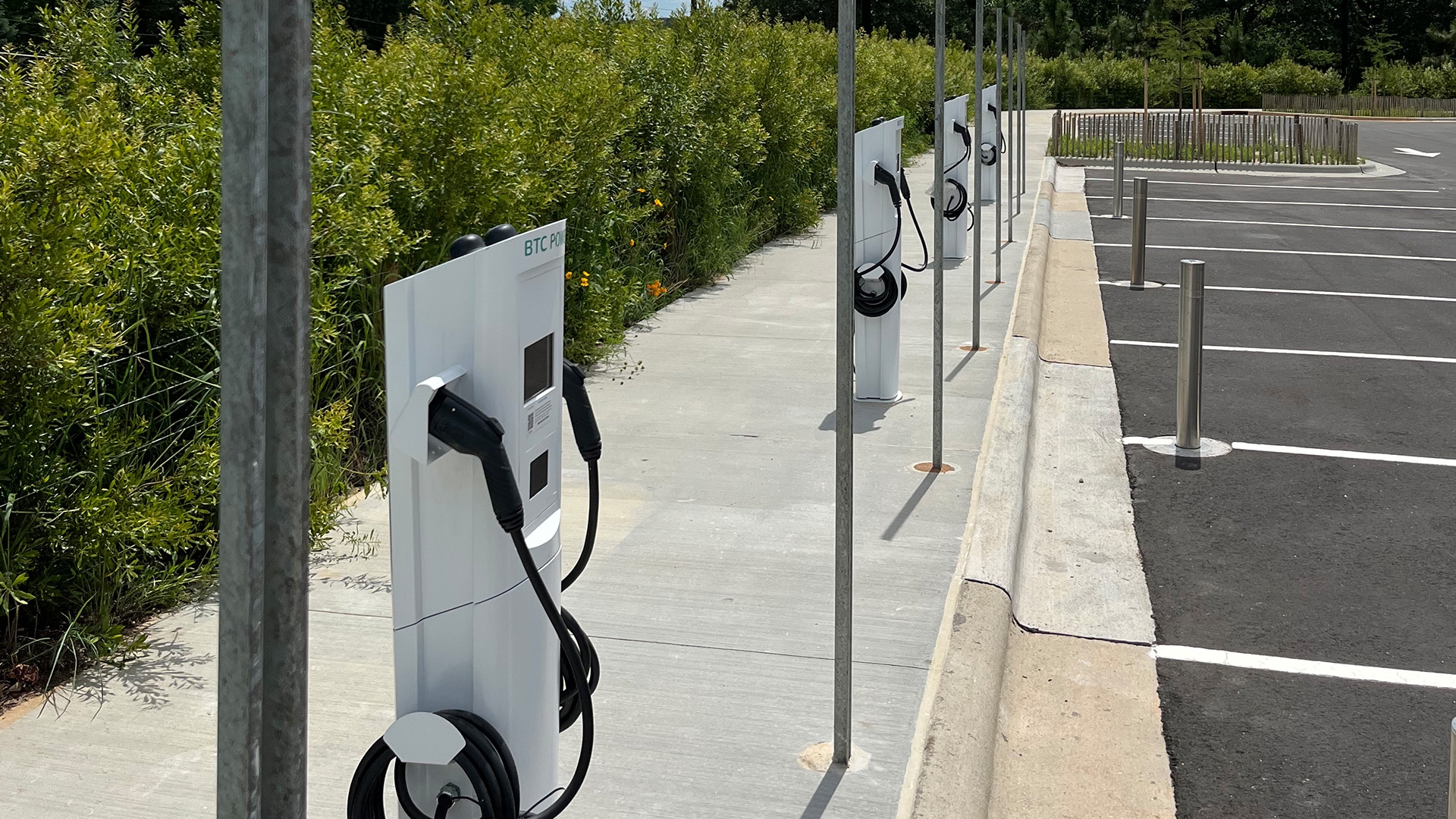 A row of electric vehicle chargers in a parking lot at Dix park. 