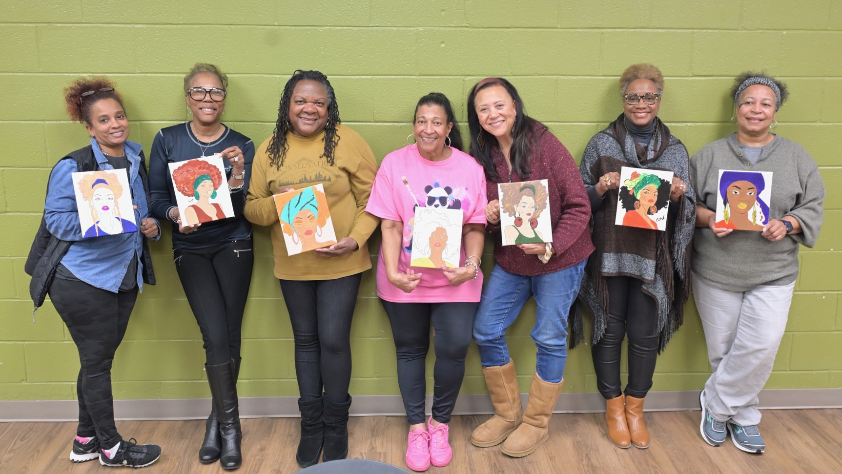 a group of people showing off the paintings they painted