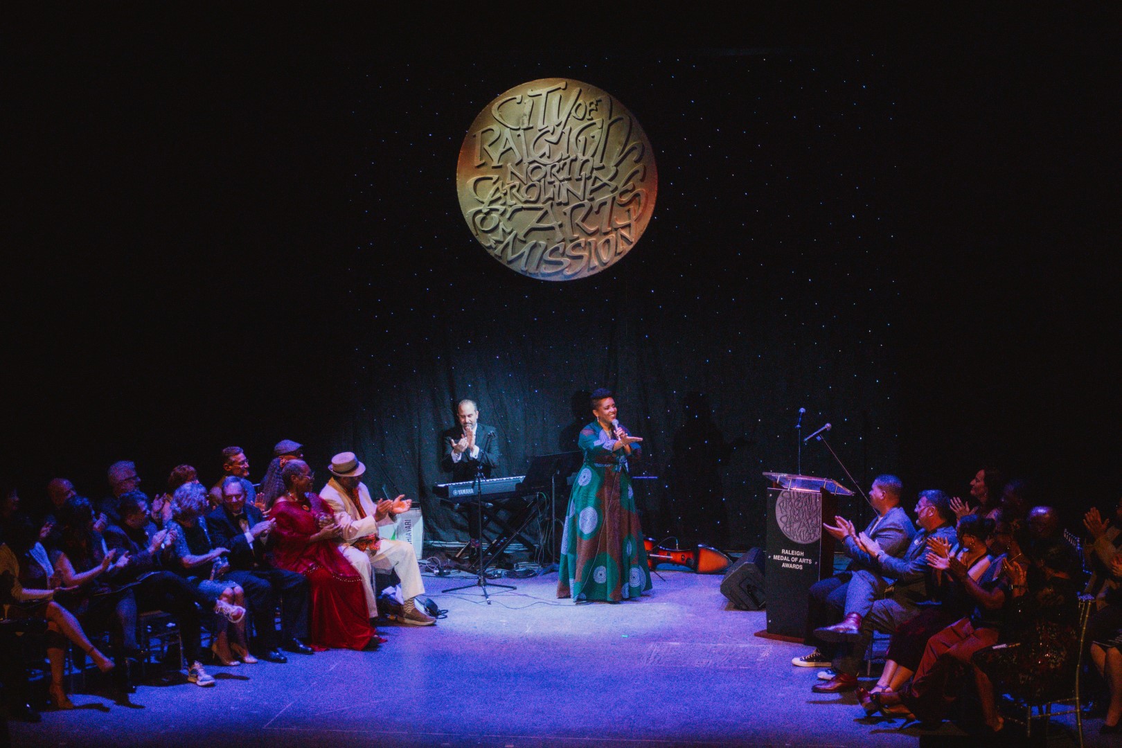 Performance with a woman signing on a stage. 