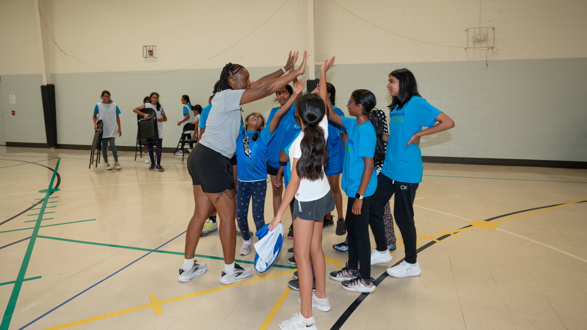 Coach giving players in a huddle a high five