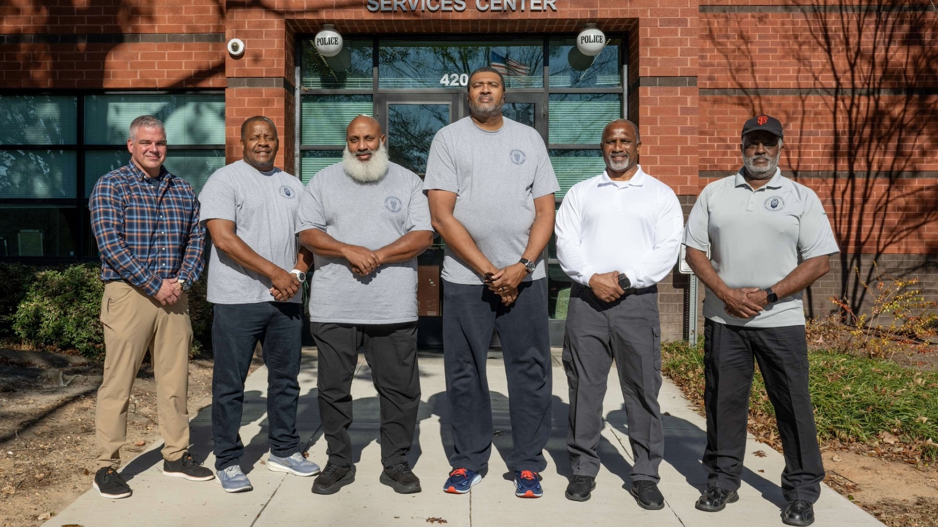 Youth mentors standing in front of brick building