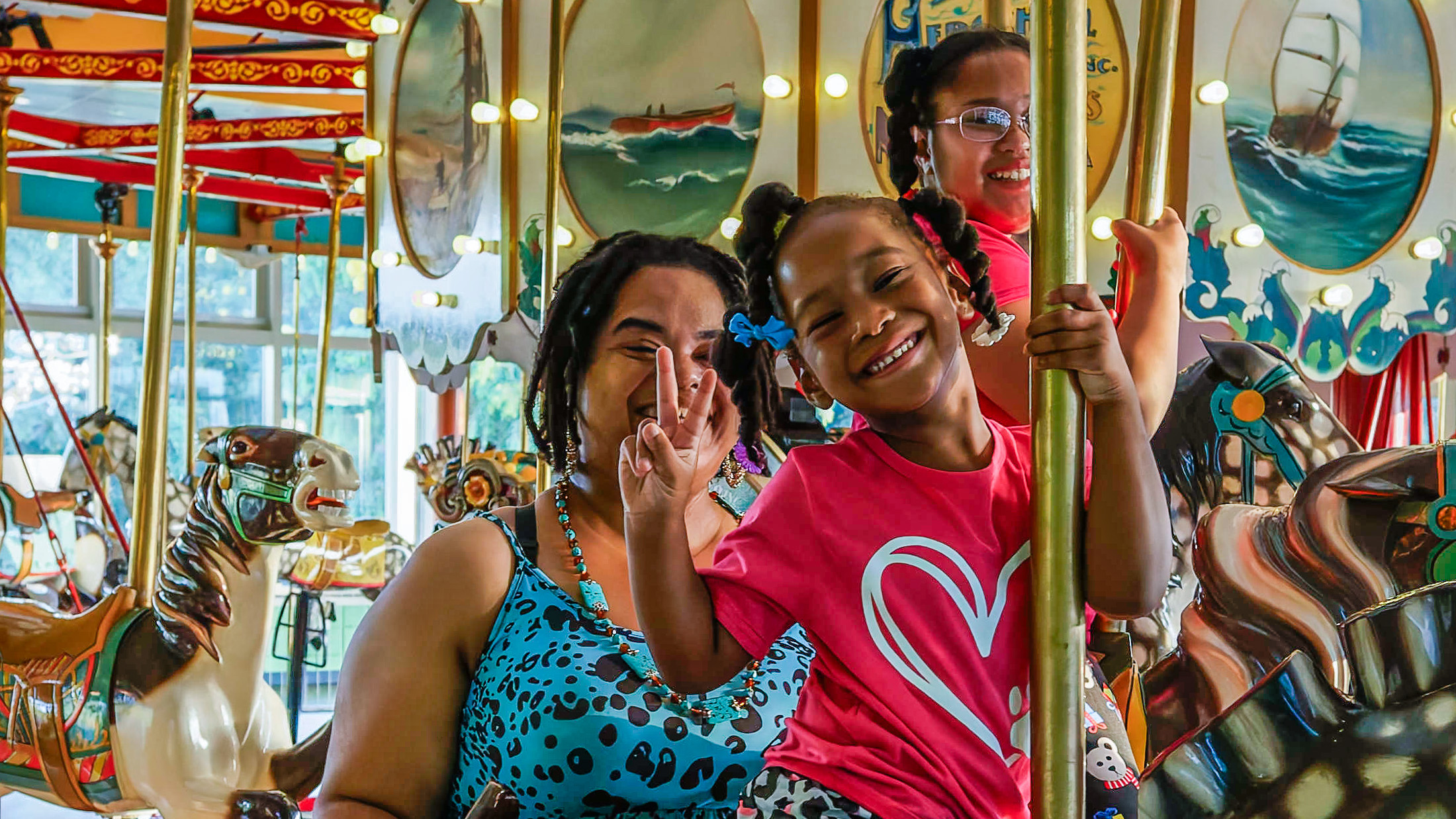 a child and adult smiling while on a carousel