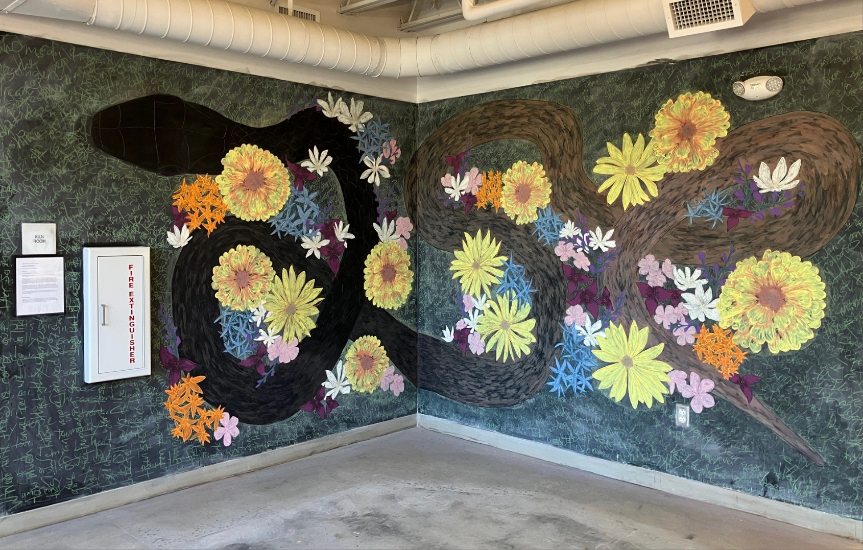 Corner chalk wall with colorful mural with flowers and a snake