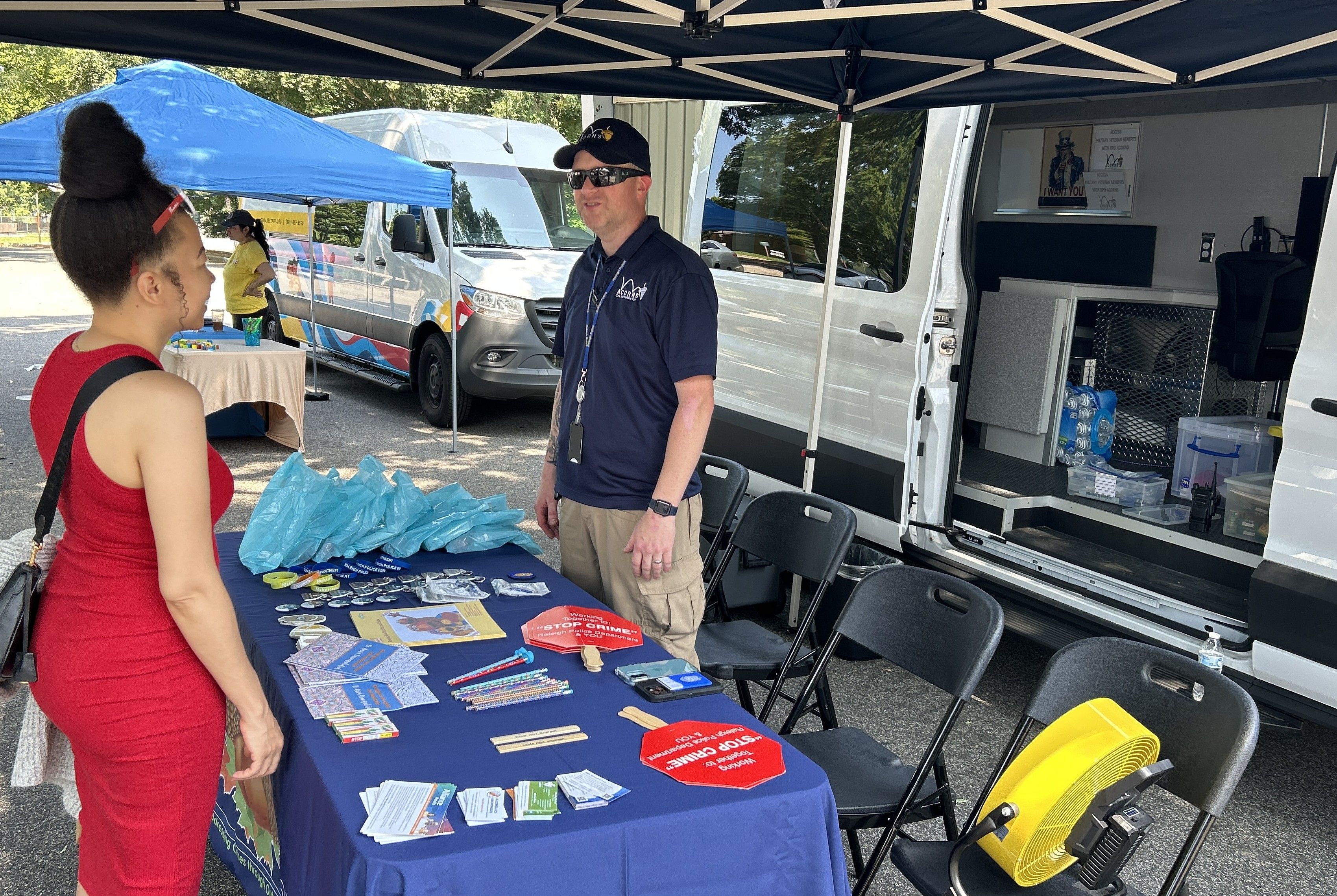 Vendor in front of mobile unit talking with community member
