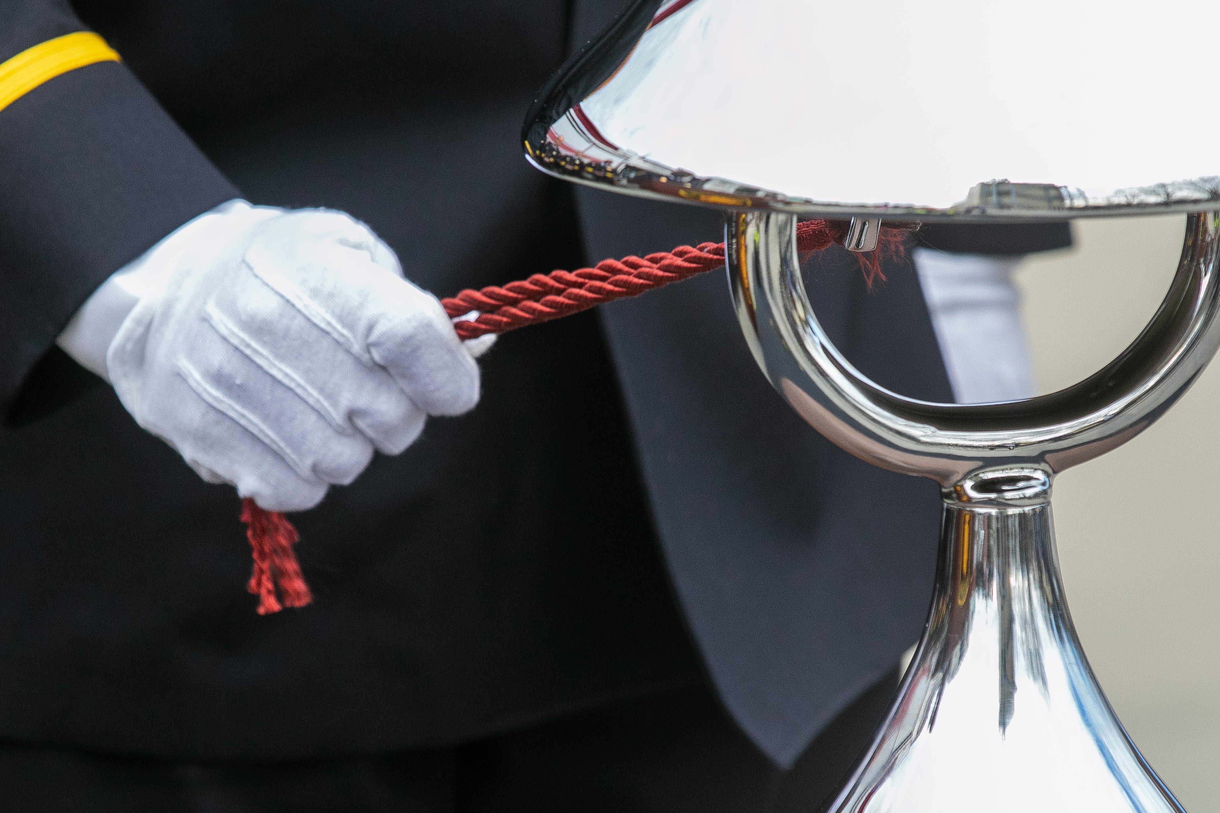 White gloved hand ringing silver bell