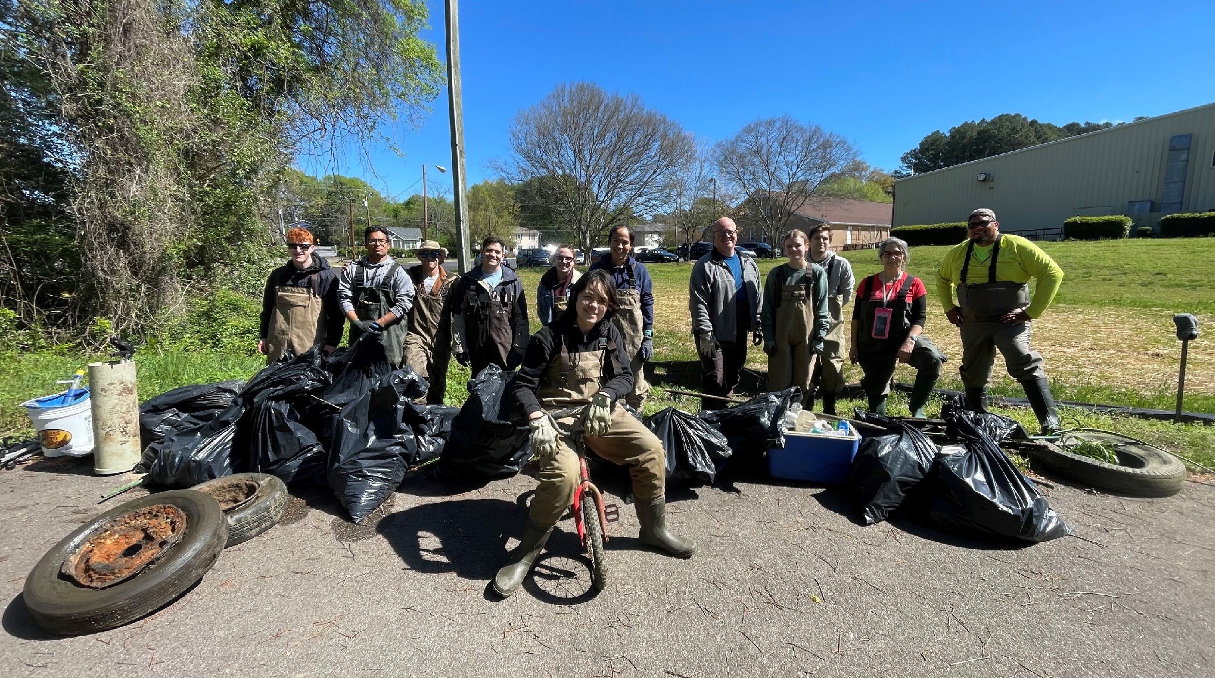 a plethora of people with trash from the creek