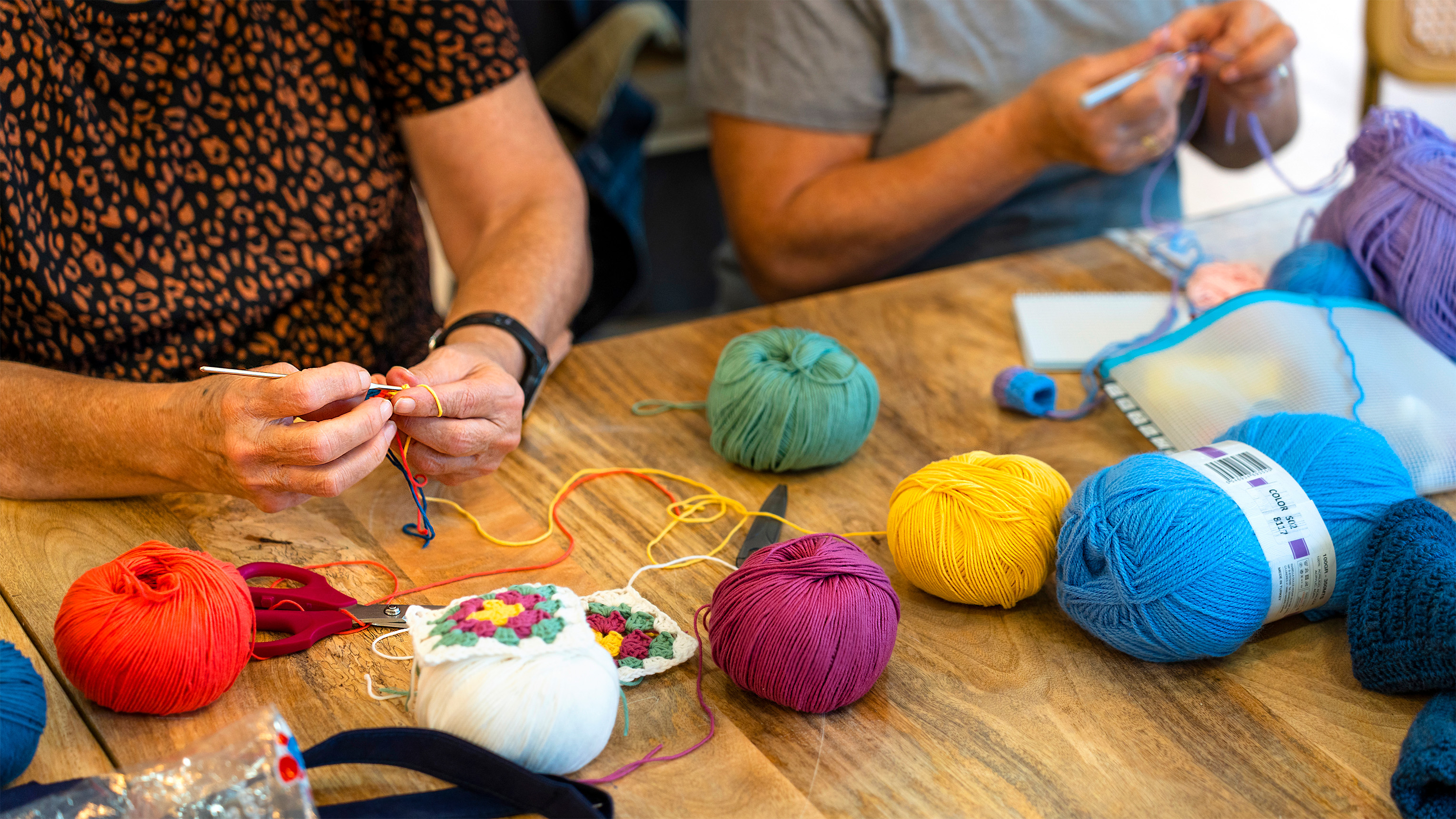 colorful yarns and hands crocheting