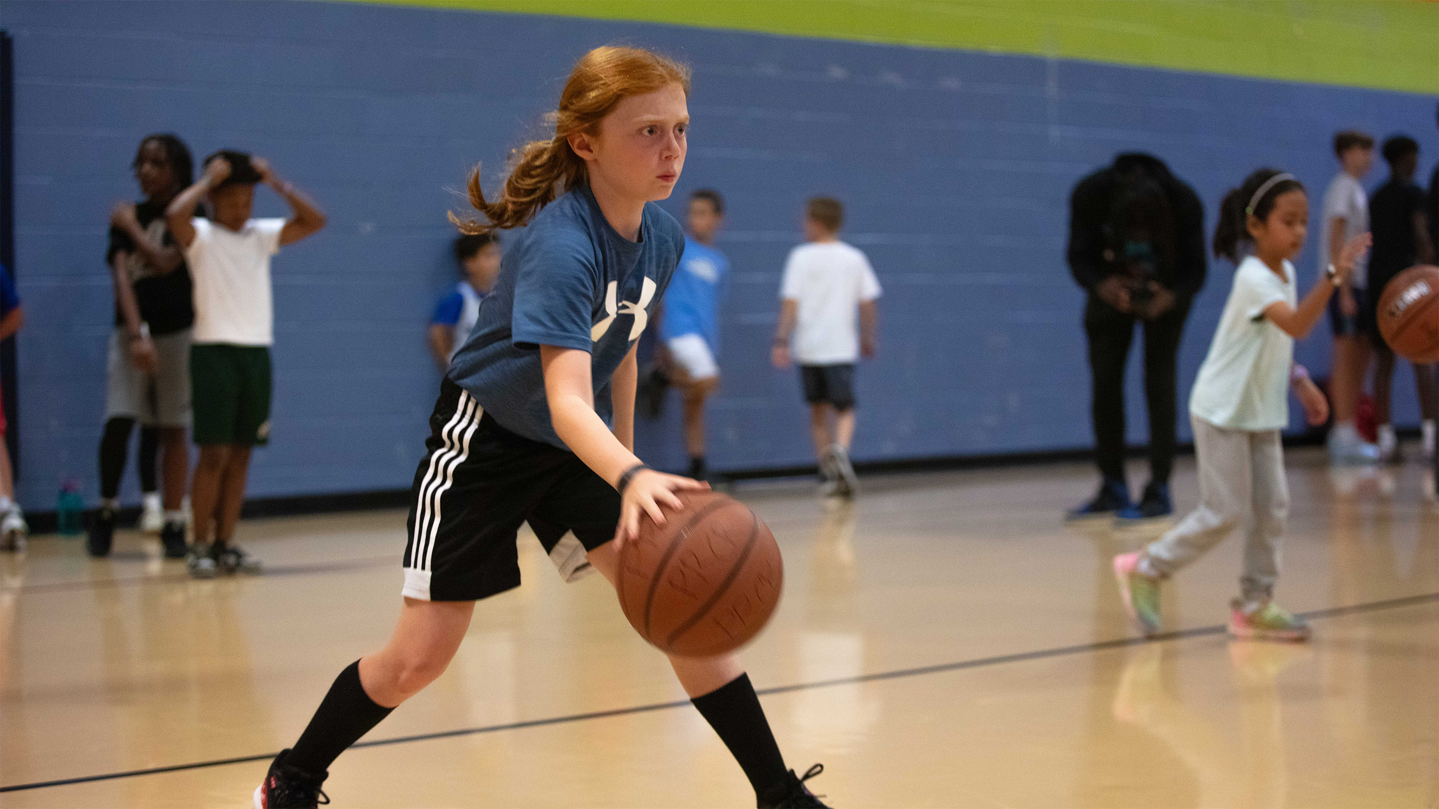 a young person dribbling the basketball