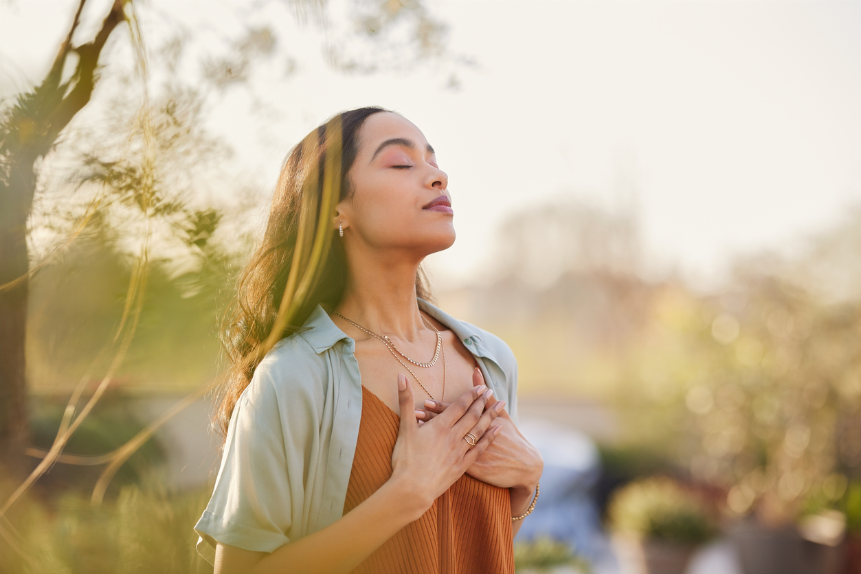 a woman focusing on breathing outside in a peaceful setting